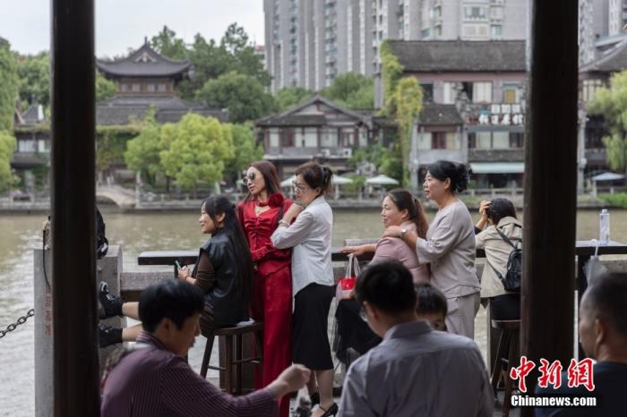 10月6日，浙江杭州，游客在京杭大运河南端的拱宸桥附近拍摄照片。 中新社记者 泱波 摄