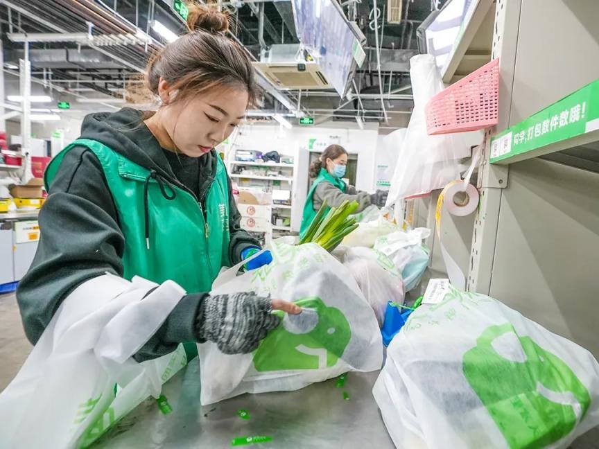美团小象超市工作人员分拣货物.